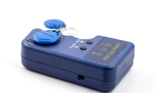 Handheld RFID writer in blue plastic housing with buttons for read and write, displayed alongside three blue RFID key fobs. Ideal for illustrating access control, cloning, or security technology tools